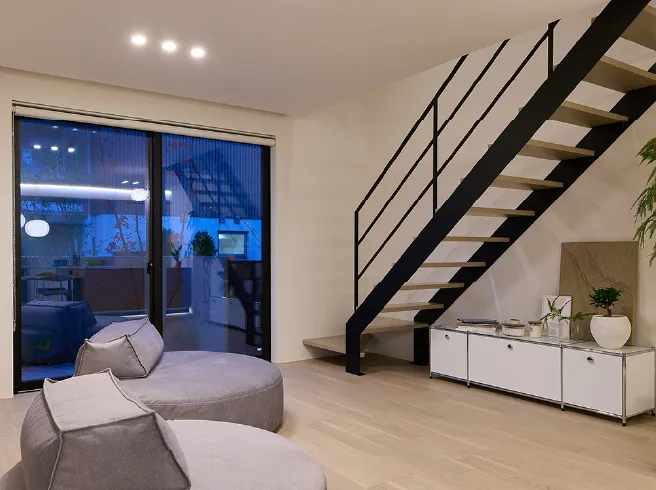 円形ソファが自然と会話を育み小さなテラスが四季の移ろいを身近に。アイアン階段が視界の広がりを演出。